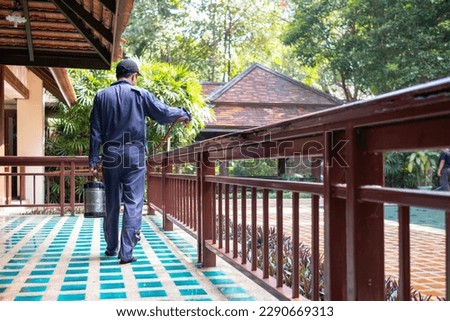 exterminate termite control company employee is using a termite sprayer at customer's house and searching for termite nests to eliminate. exterminate control worker spraying chemical insect repellant Royalty-Free Stock Photo #2290669313