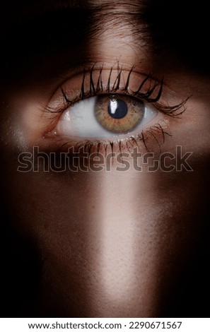 eye of a person looking through cross shaped  hole