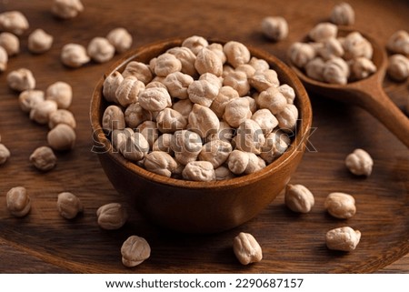 Chick pea uncooked beens. Studio shoot on wooden background. Beans spread on rustic scene. 45 degree shoot.