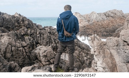 Man pissing in rocky shore by the sea Royalty-Free Stock Photo #2290693147
