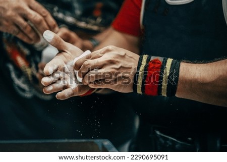 male powerlifter applying gym chalk on his hands before bench press powerlifting competition Royalty-Free Stock Photo #2290695091