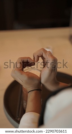 girl or woman hand making love sign with finger with coffee latte on background on coffee shop, i love caffeine