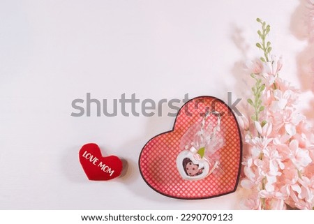 Everyday is mother's day. Mother's day concepts and Sweetest day, love concept. Red heart with the letter LOVE MOM with Beautiful flower on pink background.