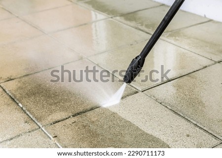 Detail of cleaning terrace with high-pressure water blaster, cleaning dirty paving stones Royalty-Free Stock Photo #2290711173