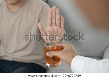 man refuses say no and avoid to drink an alcohol whiskey , stopping hand sign male, alcoholism treatment, alcohol addiction, quit booze, Stop Drinking Alcohol. Refuse Glass liquor, unhealthy, reject Royalty-Free Stock Photo #2290727769