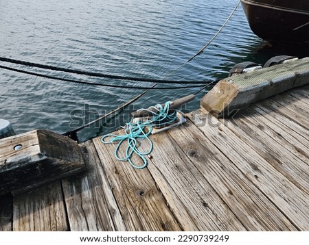 An old boat cleat with rope wrapped around it.