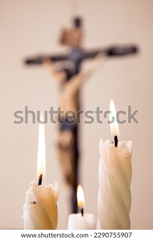 candles and wooden crucifix on brown background Royalty-Free Stock Photo #2290755907