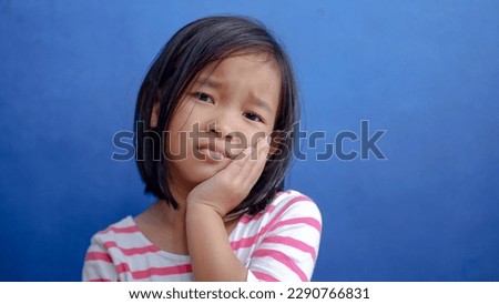Asian kid girl toothache. Kid suffering from toothache. Asian child hand on cheek face as suffering from facial pain, mumps toothache. Dental health care. Royalty-Free Stock Photo #2290766831