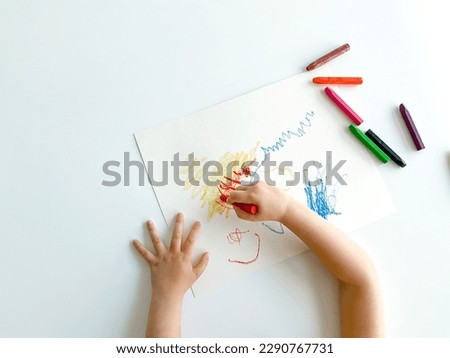 small child draws with pastel crayons on white table. fathers day Royalty-Free Stock Photo #2290767731