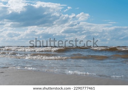 Water waves and sea tide with foam against bright blue sky horizon. Breaking wave in turquoise sea or ocean surface. Summer vacation trip. Rest and relaxation on tourist resort, hot season. Copy space