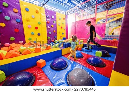 Brother with sister playing at indoor play center playground.  Royalty-Free Stock Photo #2290785445