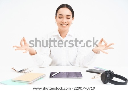 Worplace and working environment. Young woman sits in office with tablet and documents, keeps calm, meditates and smiles, relaxes, white background.