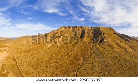 Awesome high level aspect panoramic view of the dramatic volcanic mountains and rocky landscape in the late afternoon sun on the island of Fuerteventura in the Canary Islands Spain