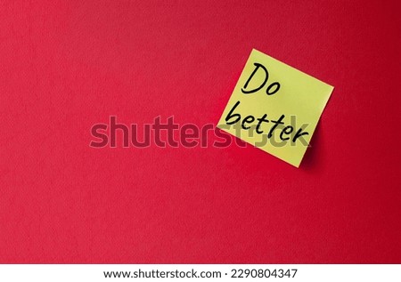 Do better symbol. Orange steaky note with concept words do better. Beautiful red background. Business and Do better concept. Copy space. Royalty-Free Stock Photo #2290804347