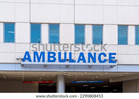 Close up of ambulance sign on the building at the entrance to a parking garage in a hospital. 