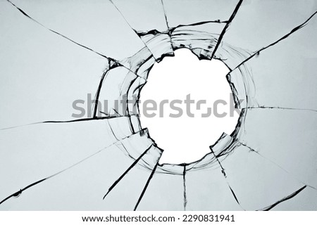 Broken window, background of cracked glass with a hole from a shot or smash. Abstract cracked texture with white background in the middle Royalty-Free Stock Photo #2290831941