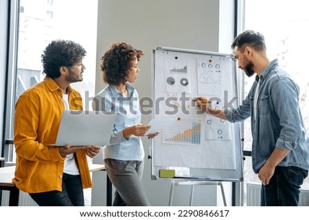 Collaboration concept, teamwork. Business people are working together on a new project, brainstorming, standing near whiteboard with financial graphs, predicting income, analyzing risks, setting goals Royalty-Free Stock Photo #2290846617