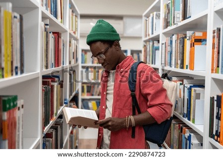 Passionate reader student african american guy choosing research textbooks in university library. Man hipster reading book studying in public place. Take education, learn, giving knowledges concept.