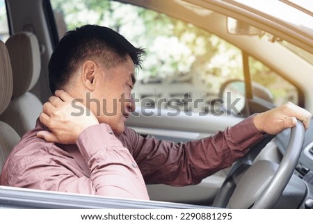 Asian man  feels hurt his neck and shoulders during his long driving in car. Concept  Injury, pain or tired from driving. Unsafe driving during abnormal symptoms. Transport, healthcare. Health problem Royalty-Free Stock Photo #2290881295
