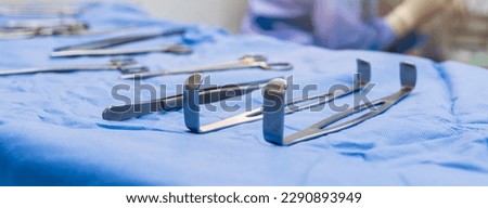 Medical or surgical instrument or tools on blue table inside operating room in hospital.Surgeon used surgical retractor in surgery.Army navy retractor for abdominal surgery.Medical technology.