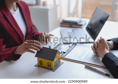 Real estate agent and customer make contract to buy and sell house and land approval of a contract to buy or sell a home offers mortgage loans and home insurance concept.