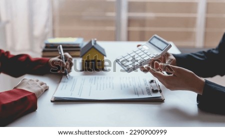 Real estate agent and customer make contract to buy and sell house and land approval of a contract to buy or sell a home offers mortgage loans and home insurance concept.