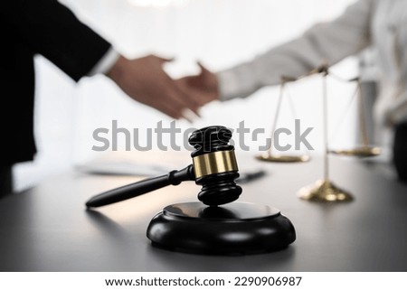 Focus gavel symbolize justice on blur background of lawyer colleagues handshake after successful legal deal for lawsuit to advocate resolves dispute in court ensuring trustworthy partner. Equilibrium Royalty-Free Stock Photo #2290906987