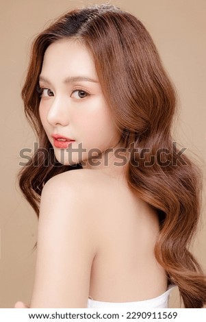 Young Asian beauty woman curly long hair with korean makeup style on face and perfect skin on isolated beige background. Facial treatment, Cosmetology, plastic surgery. Royalty-Free Stock Photo #2290911569