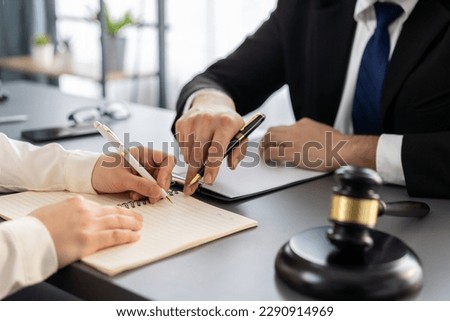 Lawyer colleagues or legal team working or drafting legal document at law firm office desk. Gavel hammer for righteous and equality judgment by lawmaker and attorney. Equilibrium Royalty-Free Stock Photo #2290914969