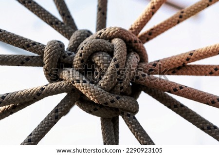 lots of ropes and a big knot against the blue sky close up Royalty-Free Stock Photo #2290923105