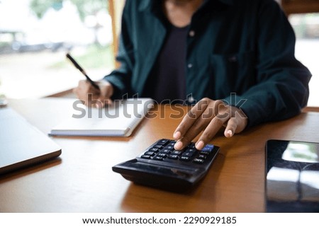 businesswoman or accountant hand typing laptop working to calculate on desk about cost at office. Royalty-Free Stock Photo #2290929185