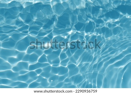 Blue water with ripples on the surface. Defocus blurred transparent blue colored clear calm water surface texture with splashes and bubbles. Water waves with shining pattern texture background. Royalty-Free Stock Photo #2290936759