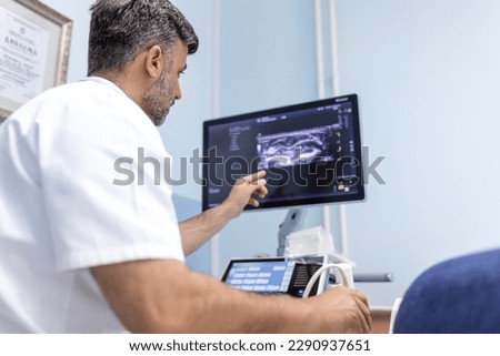 At the medical clinic, Caucasian male doctor doing the doppler ultrasound test evaluation of arteries and veins on a female patient Royalty-Free Stock Photo #2290937651