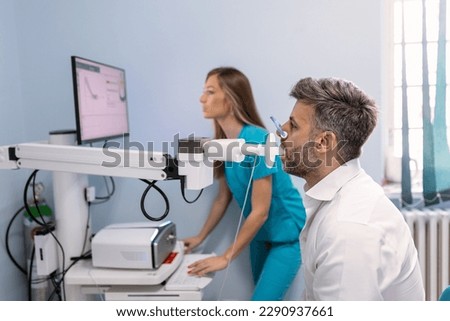 Man testing breathing function by spirometry. Diagnosis of respiratory function in pulmonary disease Royalty-Free Stock Photo #2290937661
