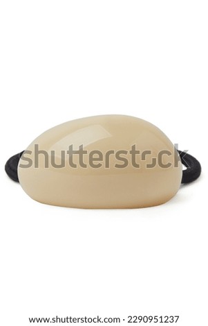 Close-up shot of a black hair band with a beige decoration. The hair accessory for women is isolated on a white background. Front view.