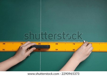 Woman drawing with chalk and ruler on green board, closeup. Space for text