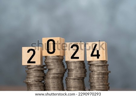 Wooden block cube from 2024 on coins stacking for setup objective target business cost and budget planing of new year concept. Free space can put advertising materials.