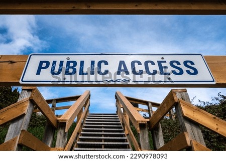 Steep wooden outdoor stairs and sign indicating public access.