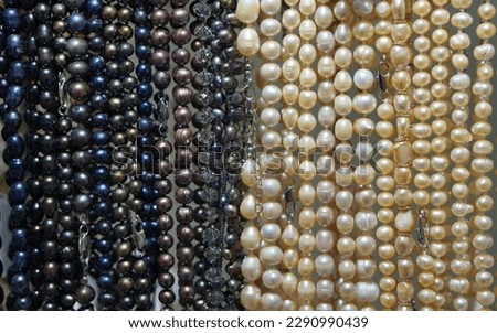 background with beads of white and contrasting black pearls close-up