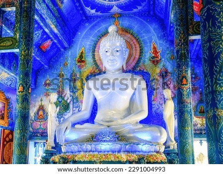 Illuminated Modern White Buddha Statue in the famous Blue Temple Wat Rong Suea Ten Complex in Chiang Rai, Thailand