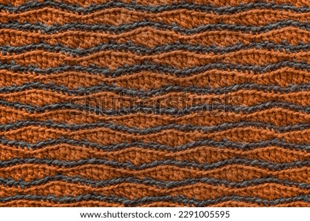 Orange grey crochet wave pattern. Knitted texture.