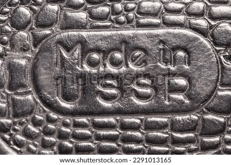 Natural black crocodile skin texture and background, with the inscription Made in USSR. Royalty-Free Stock Photo #2291013165