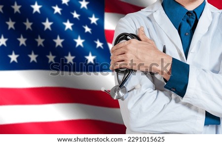 Doctor with stethoscope on USA flag. Health and care with the flag of United State. USA national health concept, Doctor arm holding stethoscope on USA flag Royalty-Free Stock Photo #2291015625