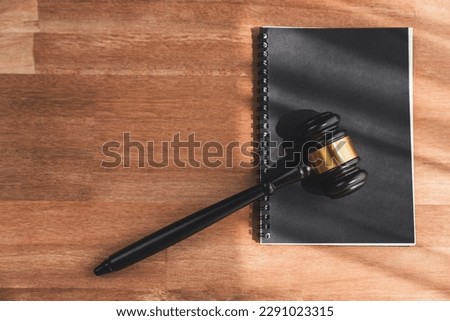 Top view black wooden gavel hammer and law book on wooden office desk background as justice and legal system for lawyer and judge, Legal authority and fairness in trials concept. equility