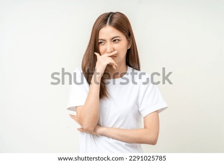 Bad smell stinks. Young beautiful asian woman pinching nose with disgust. Holding breath with fingers on nose Royalty-Free Stock Photo #2291025785