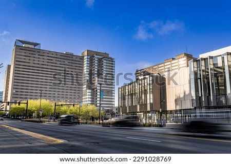 Traffic on Main Street in Lexington, Kentucky in front of tall business office buildings, hotels, and newly build convention center and sports arena Royalty-Free Stock Photo #2291028769