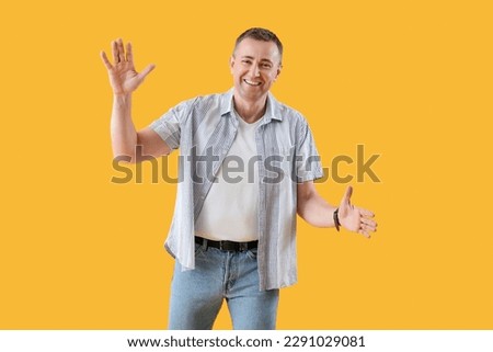 Mature man opening arms for hug on yellow background. Hello concept