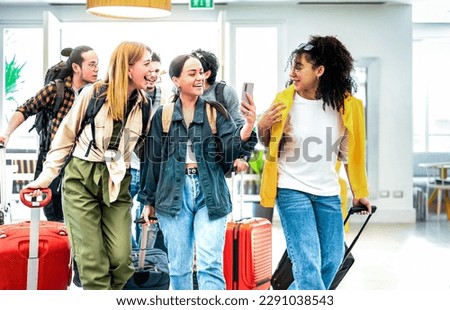Multi racial diverse friends group arriving at hotel resort lobby with suitcases - Travel vacation life style concept with young people having fun before checkin time - Bright vivid backlight filter Royalty-Free Stock Photo #2291038543
