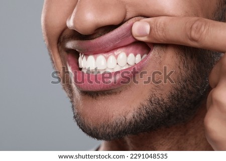 Man showing healthy gums on grey background, closeup Royalty-Free Stock Photo #2291048535