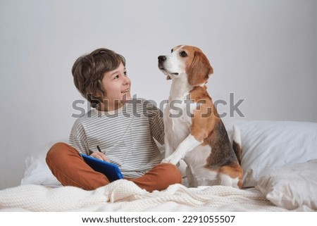 boy and faithful beagle sharing a loving embrace in a charming snapshot. Picture perfect moment of a dog lover cuddling with his furry companion, radiating happiness